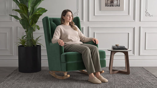 Emerald green tufted velvet rocking chair with a wooden base in a neutral living room.