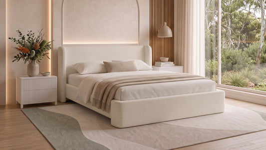Cream upholstered bed with neutral bedding in bright modern bedroom