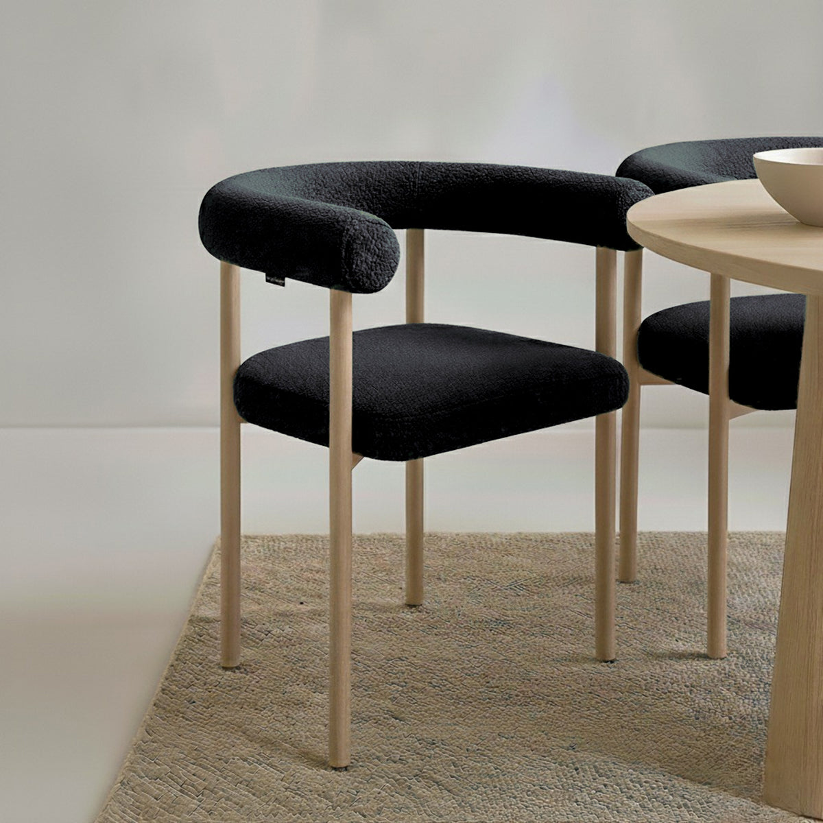 Ohio Curved Boucle Dining Chair Set of 2 in Black & Oak features a sleek design with a tubular black upholstered backrest, seat cushion, and slender light-wood legs, perfect for modern dining spaces.