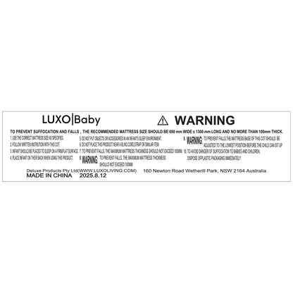 Eudora Classic Solid Wood Baby Cot in White with safety label detailing mattress size, usage instructions, and warnings. Features solid pine construction, adjustable base, and compliance with safety standards.
