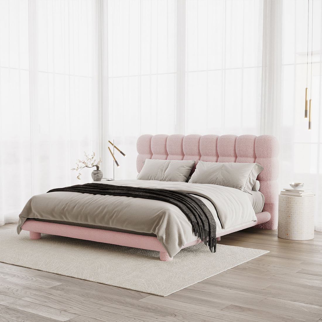Pink boucle king bed frame with vertical channel tufting on headboard, shown with grey bedding and black throw in bright room