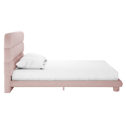 Pink boucle king bed frame with channel-tufted headboard, white mattress and two white pillows, side view
