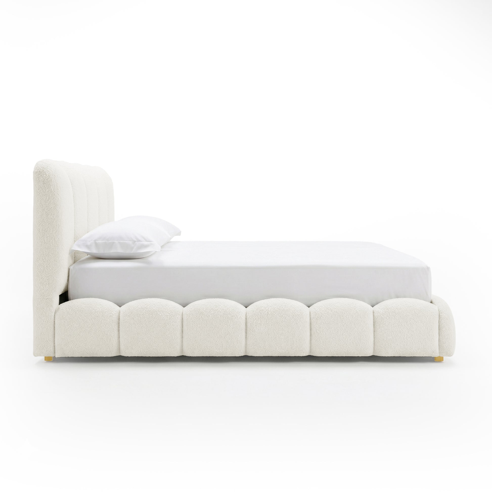 Brent double gas lift bed with scalloped base, boucle cream white upholstery, curved headboard, brass feet, white bedding