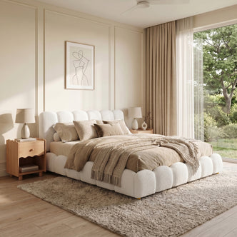 Brent King Gas Lift Bed in Boucle Cream White with curved headboard and footboard, shown with beige bedding in a light-filled