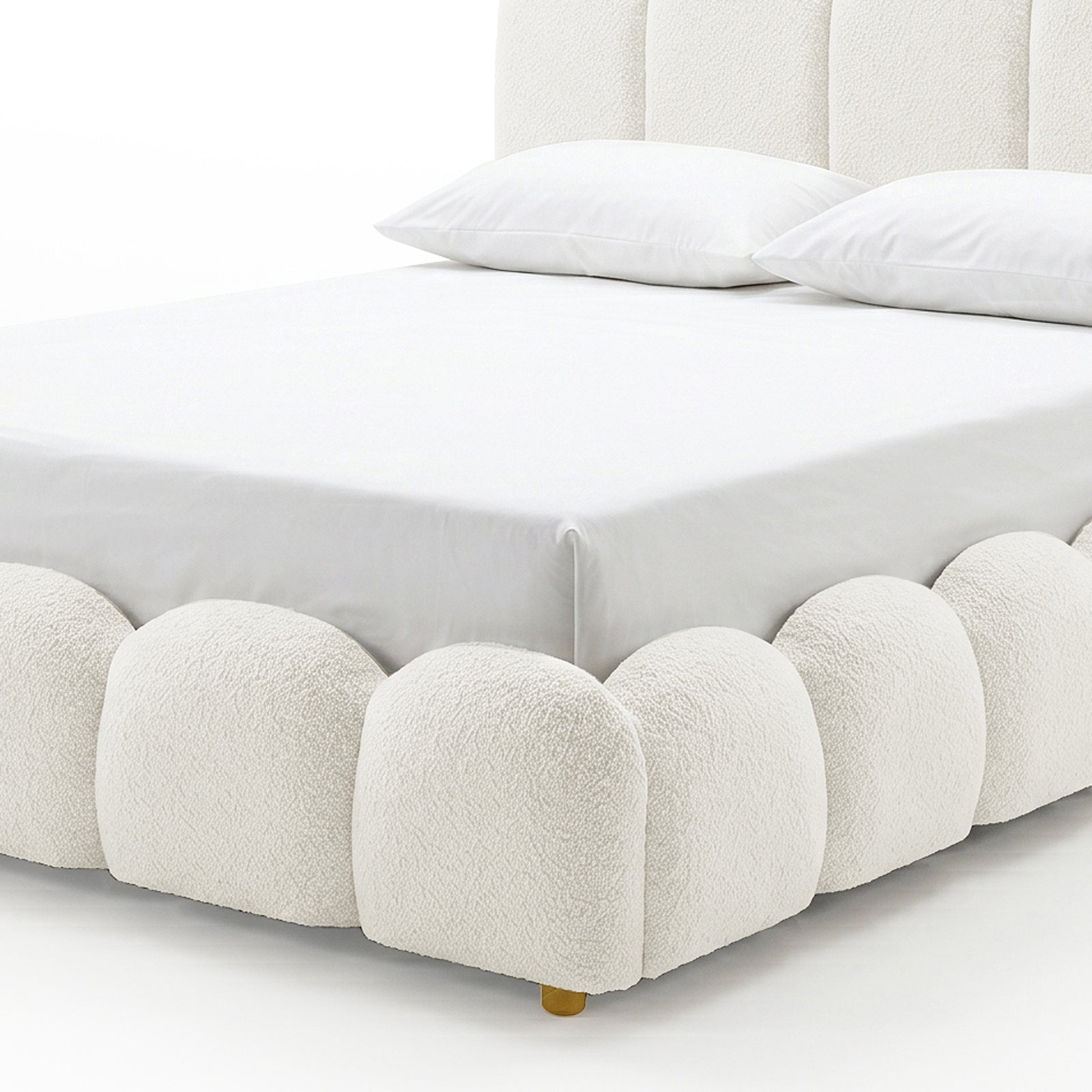 Close-up of the scalloped base and brass foot of the Brent King Gas Lift Bed in Boucle Cream White, showing white bedding