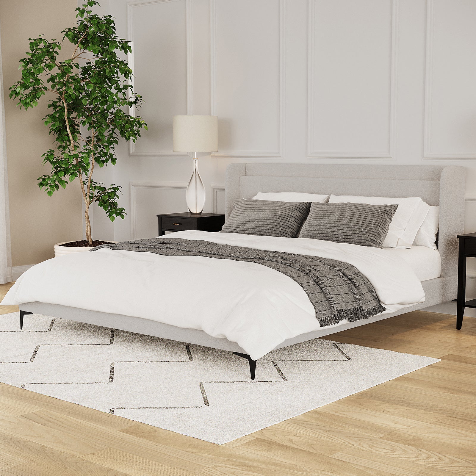 Beige boucle king bed frame with winged headboard, black legs, styled with white bedding and grey throw
