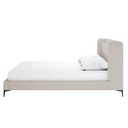 Beige boucle king bed frame with winged headboard, white mattress and pillow, black metal legs, side view