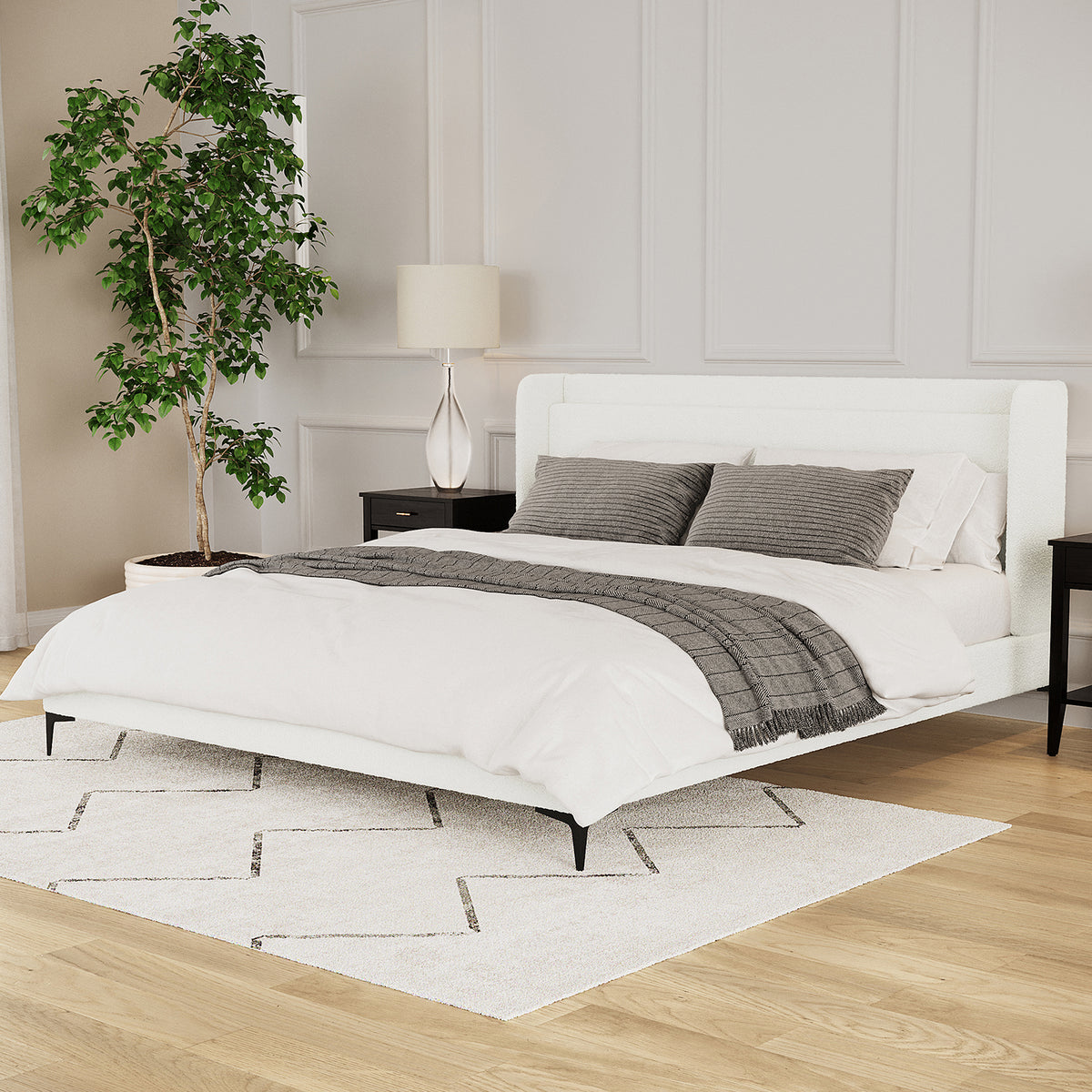 Cream white boucle king bed frame with winged headboard, black legs, styled with white bedding and grey accent pillows