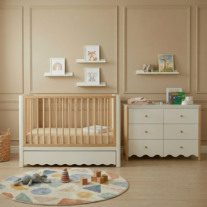 Natural pine wood baby cot with white base and storage drawer in nursery with matching chest of drawers