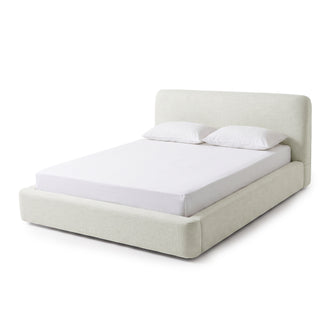 Modern upholstered bed with mattress and two pillows on a white background