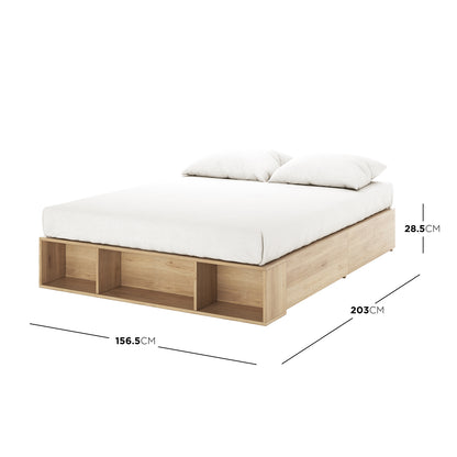 Eulalia Queen Storage Platform Bed Base with Drawer in Oak features a low-profile design, white mattress, two pillows, three open cubby compartments at the foot, and dimension callouts for size reference. - Dimensions