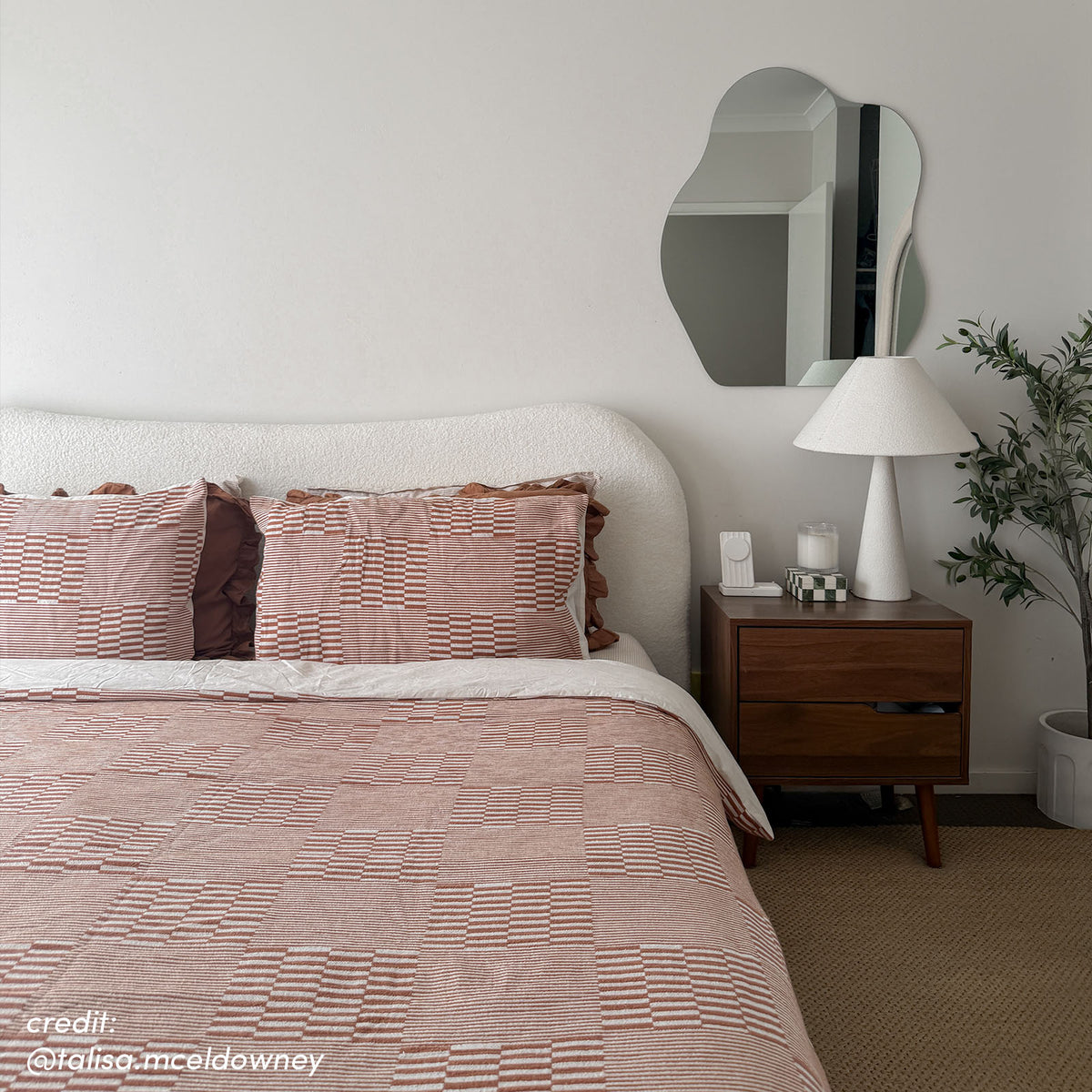 Ginnie Bouclé Curved King Bed Frame in Cream White with textured curved headboard, styled with rust-patterned bedding, beside