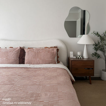 Ginnie Bouclé Curved King Bed Frame in Cream White with textured curved headboard, styled with rust-patterned bedding, beside