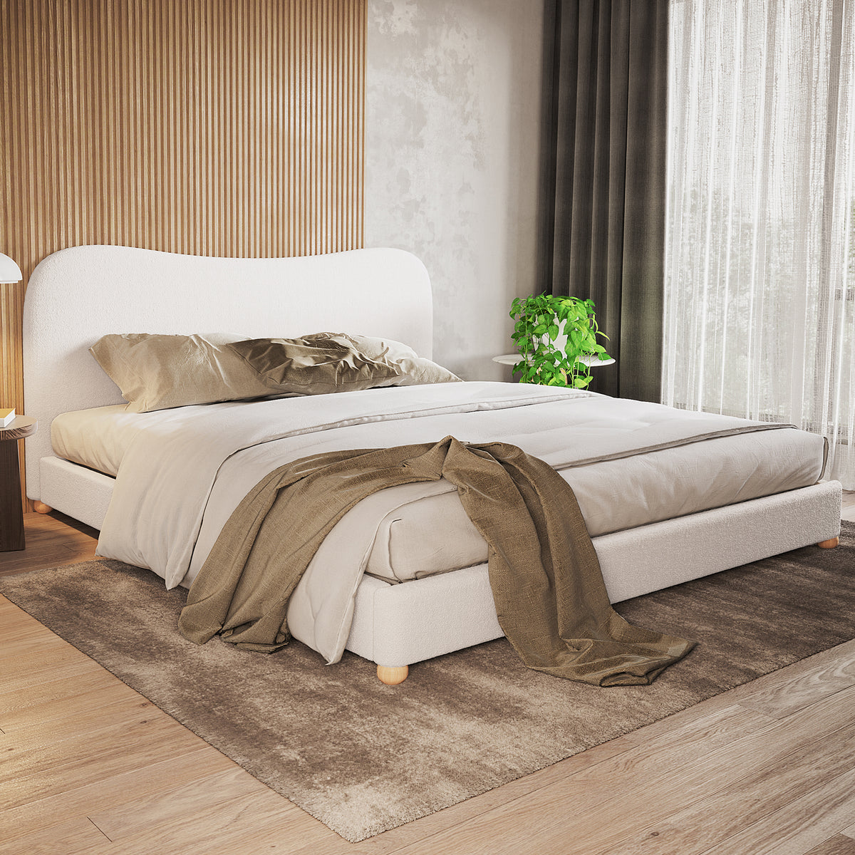Ginnie Curved Bouclé Bed Frame - Cream White, features a low-profile design with a curved headboard, upholstered in soft bouclé fabric. Styled with neutral linens and a taupe-brown throw in a minimalist bedroom.