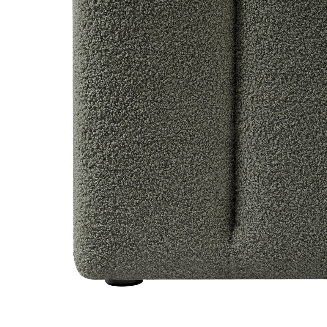 Close-up of the Aquila Queen Extra Wide Bouclé Headboard in Green, showcasing its textured gray-green bouclé fabric and a small, round black foot beneath, suggesting a plush, modern design.