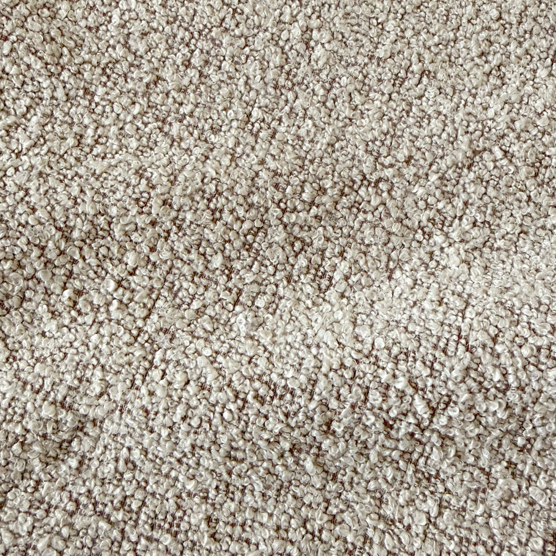 Close-up of warm beige textured fabric upholstery with woven pattern