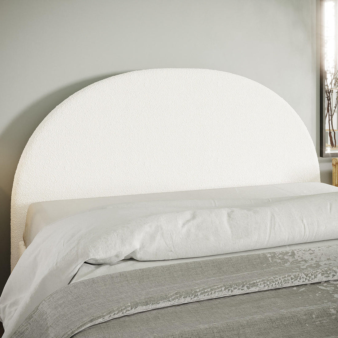 Florus Bouclé Queen Upholstered Round Bed Headboard - Cream White, featuring a textured, semicircular design against a pale gray wall, complemented by a light duvet and grayish throw.