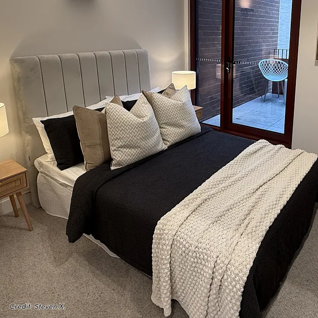 Gratiana Queen Velvet Fabric Headboard in Slate with vertical channel tufting, shown in a bedroom with black and white