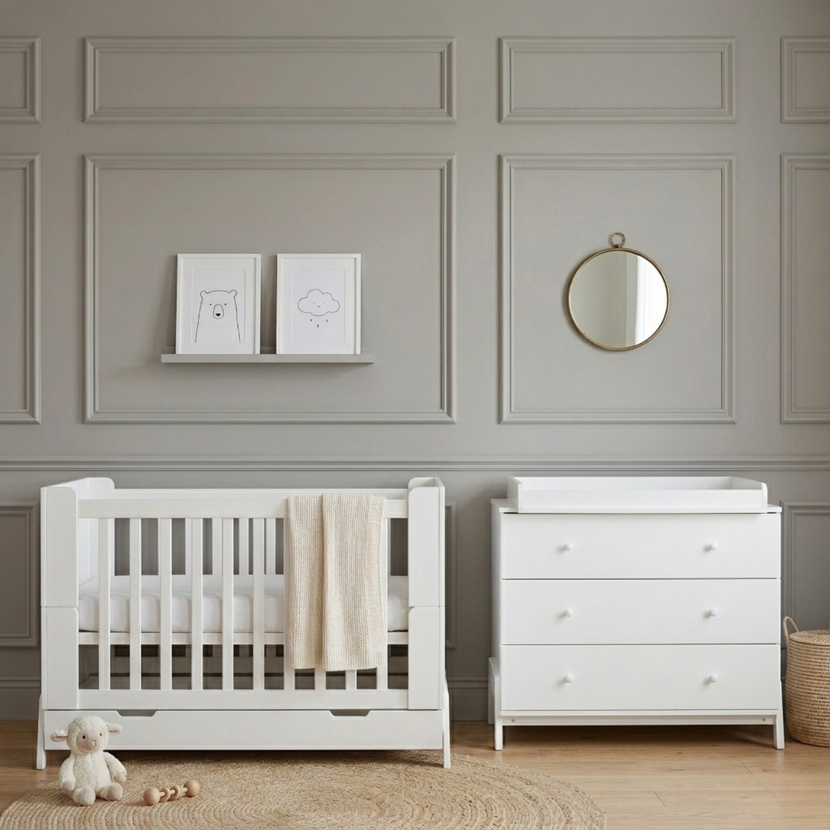 White baby cot with pull-out storage drawer and vertical slats, shown beside white chest of drawers in grey panelled nursery