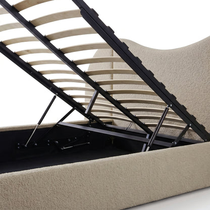 Beige boucle upholstered king bed frame with gas lift storage mechanism, wooden slats and black metal frame raised to reveal
