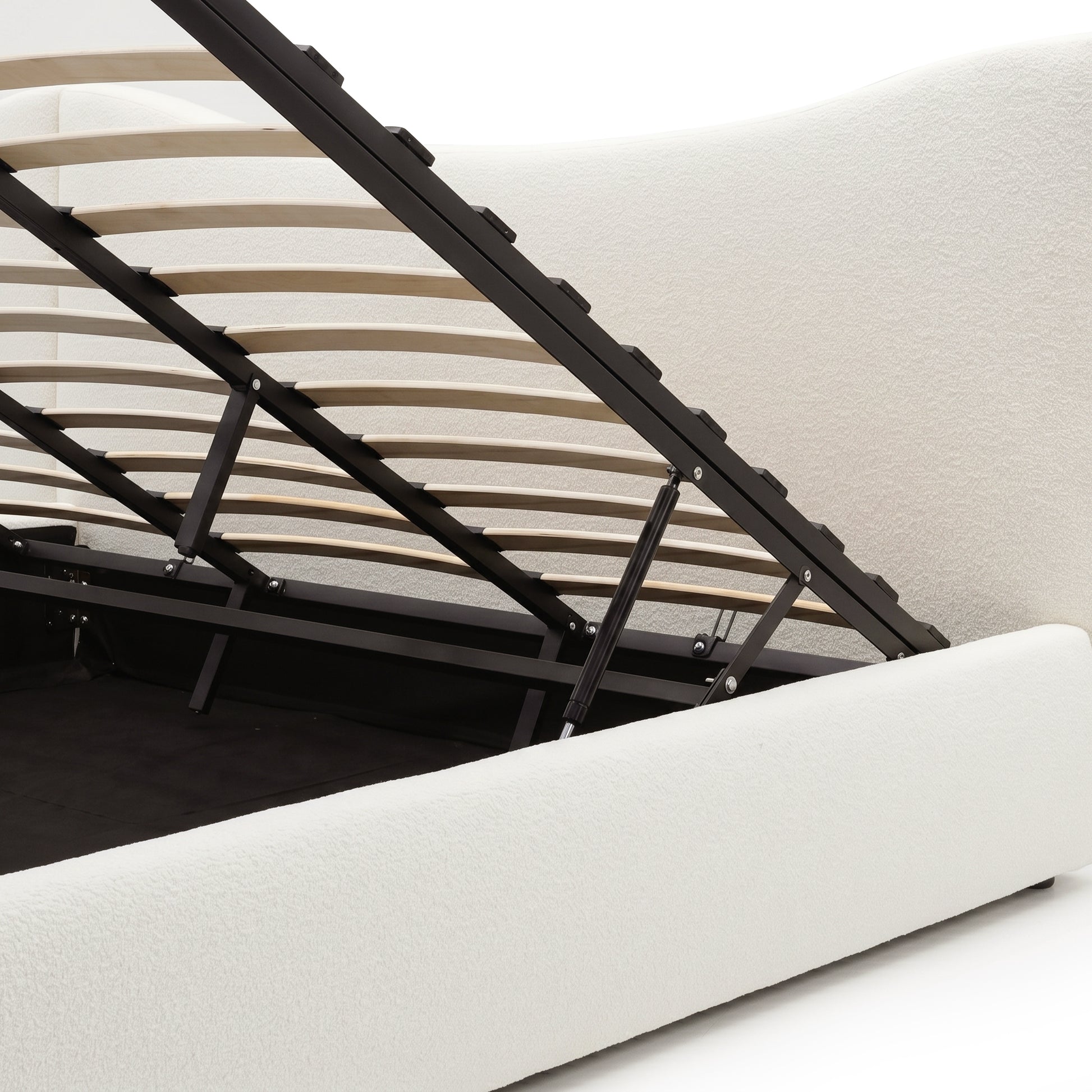Cream boucle upholstered gas lift storage bed frame with black metal frame and wooden slats raised to show under-bed storage
