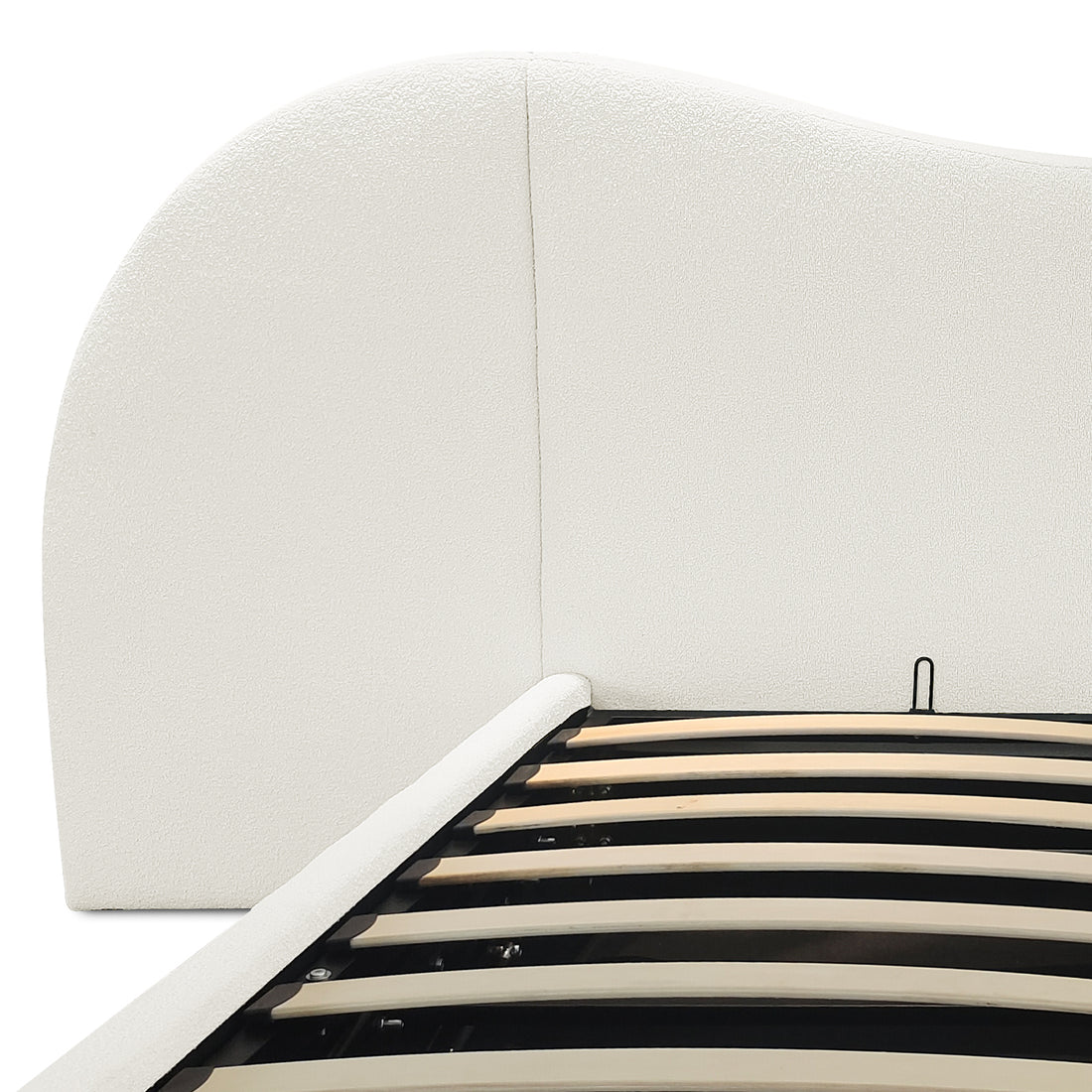 Close-up of cream white boucle upholstered curved headboard and gas lift slatted base