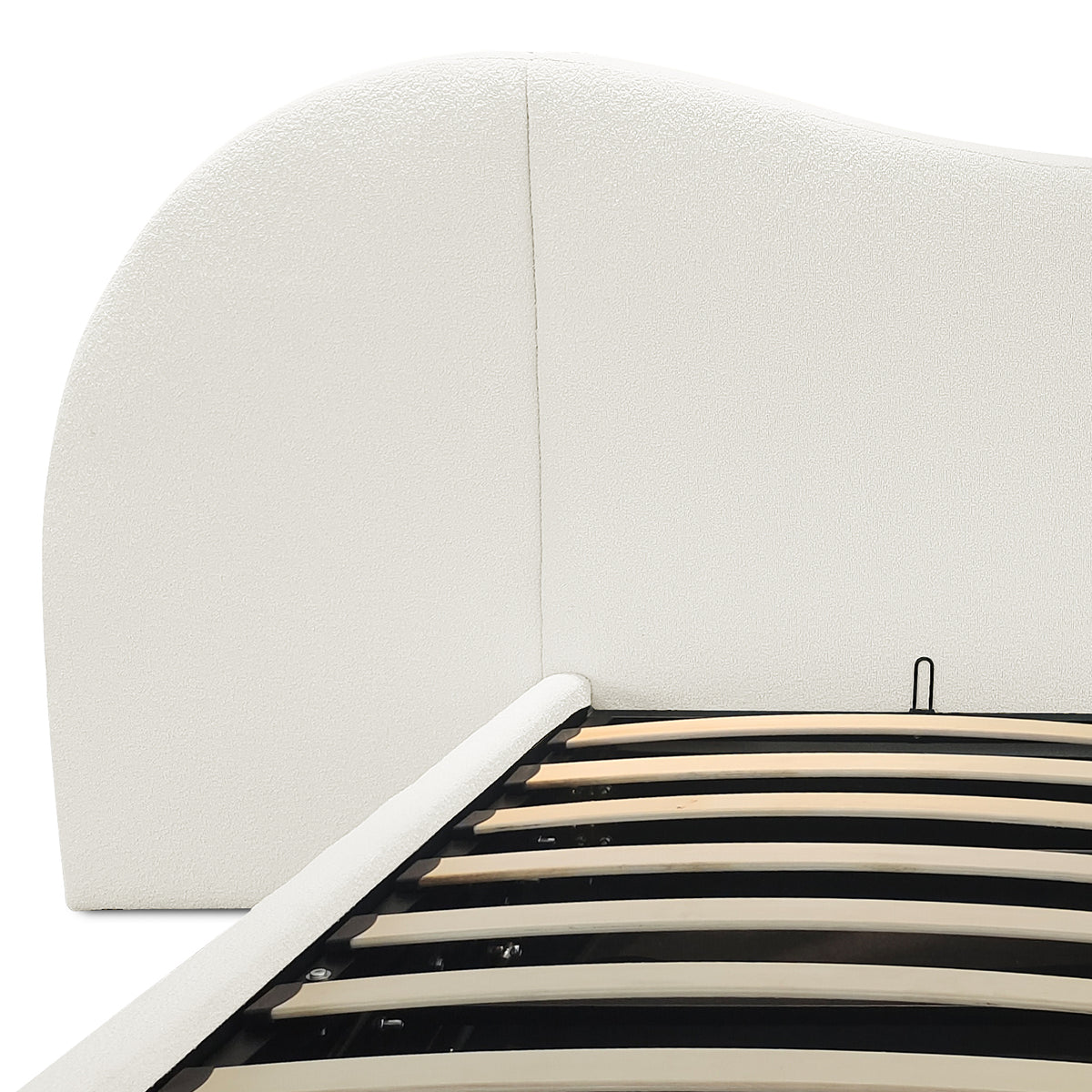 Close-up of cream white boucle upholstered curved headboard and gas lift slatted base