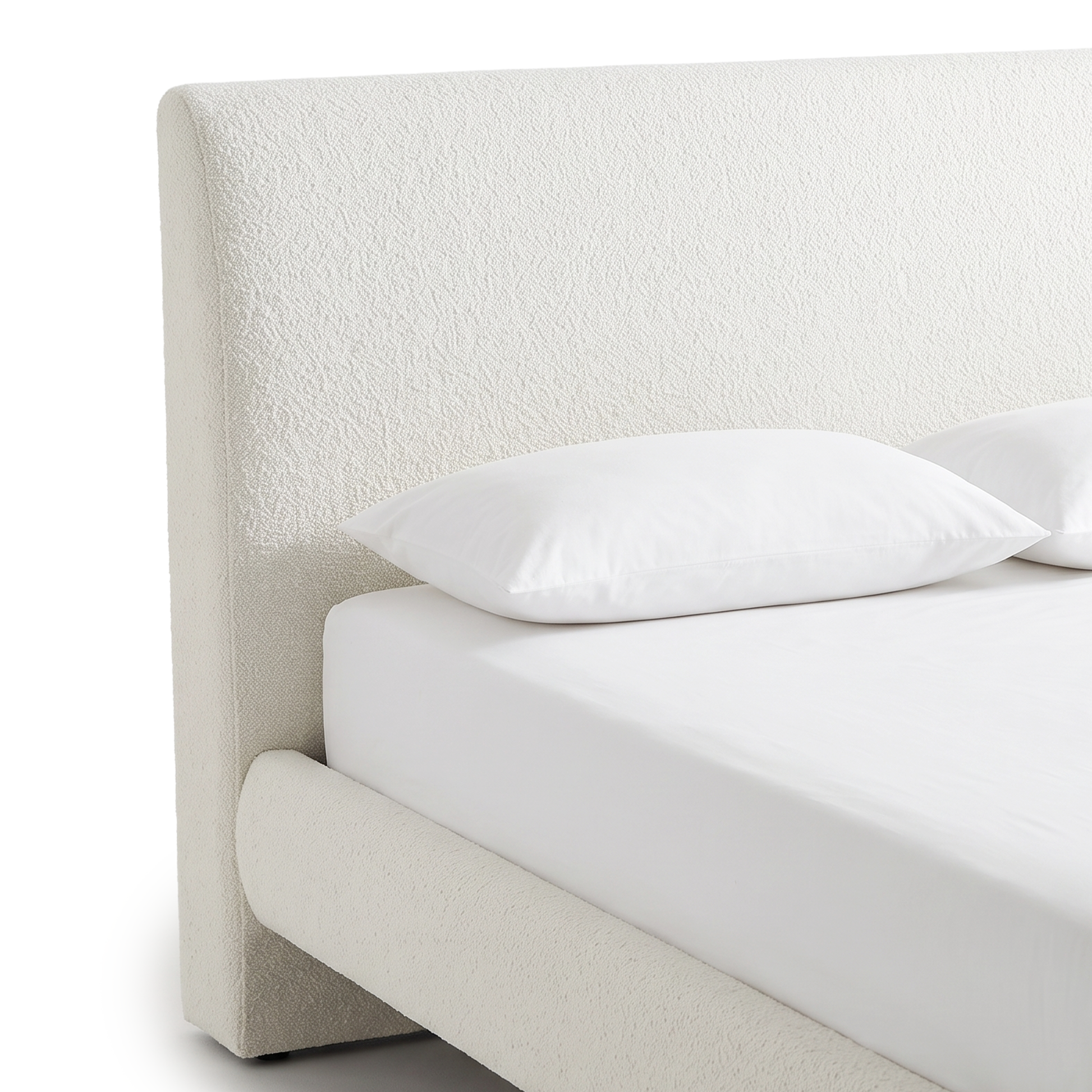 Alt-text: A close-up view of the white bouclé headboard and upholstered side rail of a modern bed frame with white bedding on a white background.