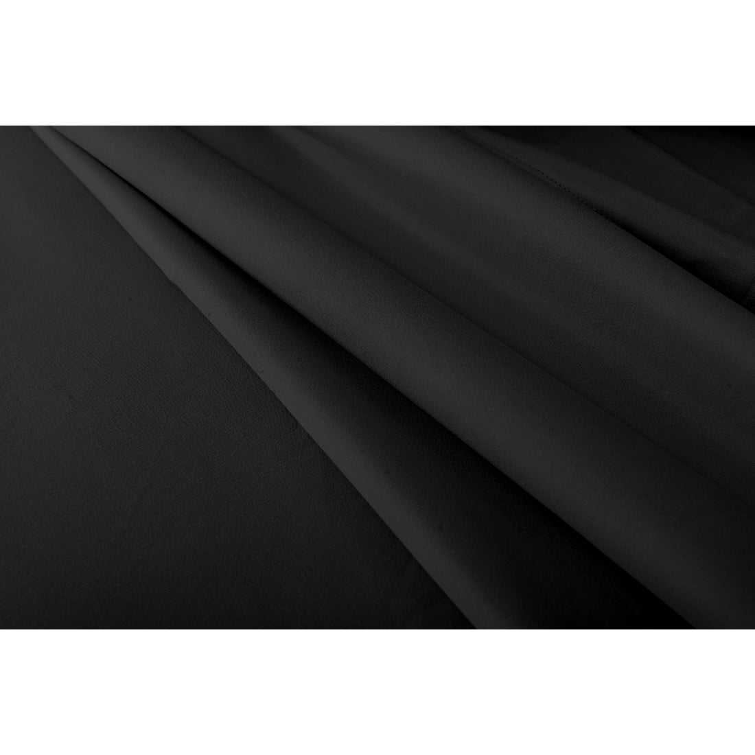 Close-up of folded black bed sheet fabric showing smooth texture and subtle sheen