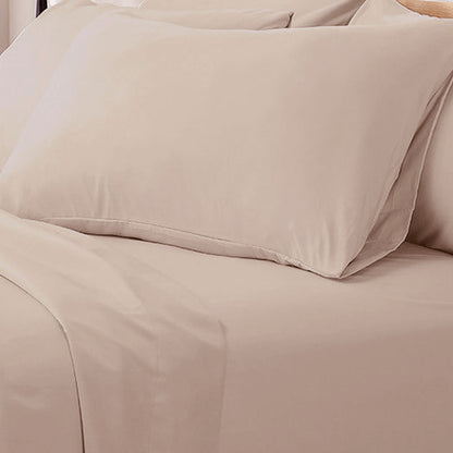 Close-up of cream fitted sheet and pillowcase showing stitching detail