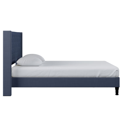 Maggie King Winged Fabric Bed Frame – Dark Blue: Features a tall, tufted headboard, low platform footboard, upholstered in deep blue fabric, with a white mattress and pillows for a regal bedroom centerpiece.