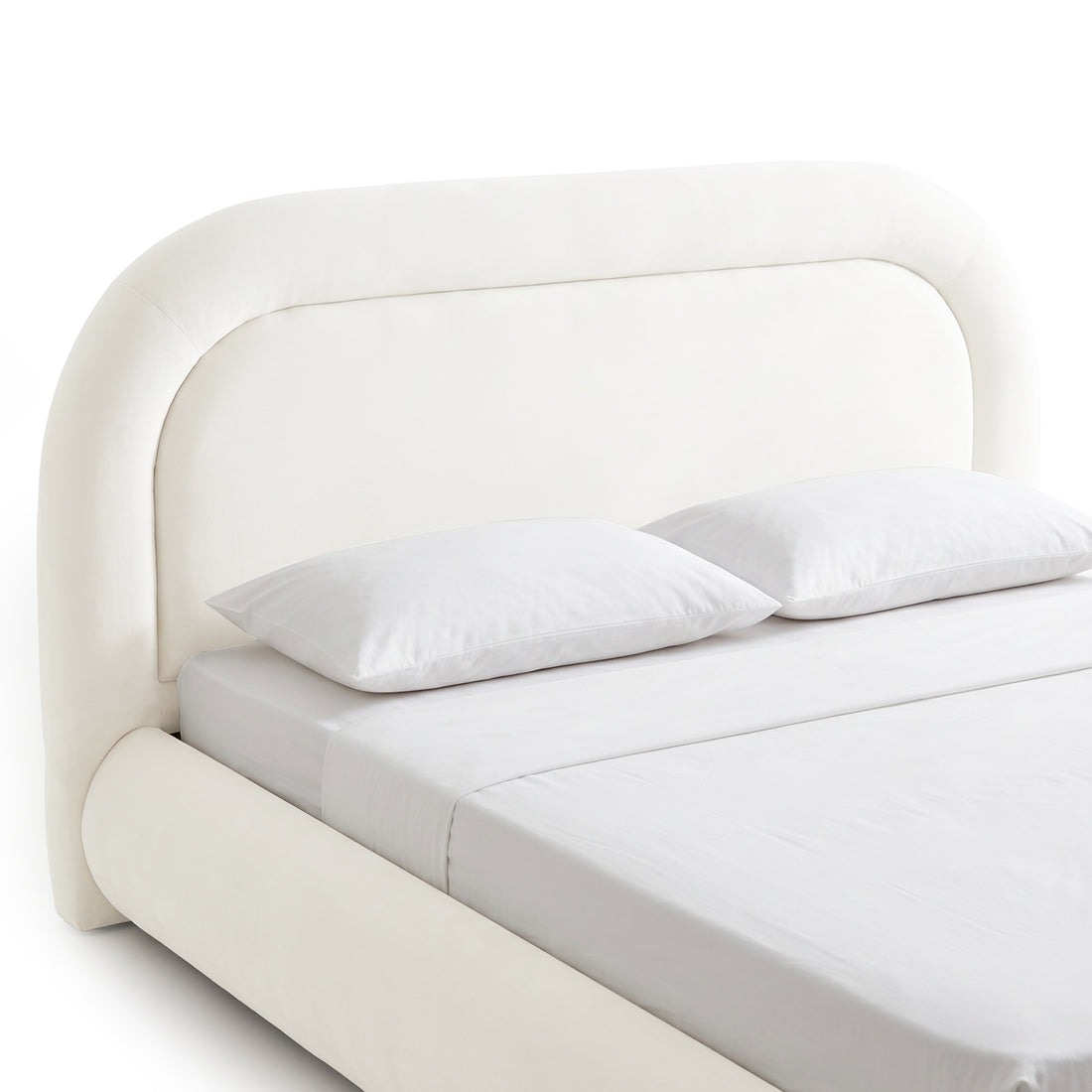 Cream white upholstered bed frame with curved headboard and gas lift storage base, shown with mattress and pillows