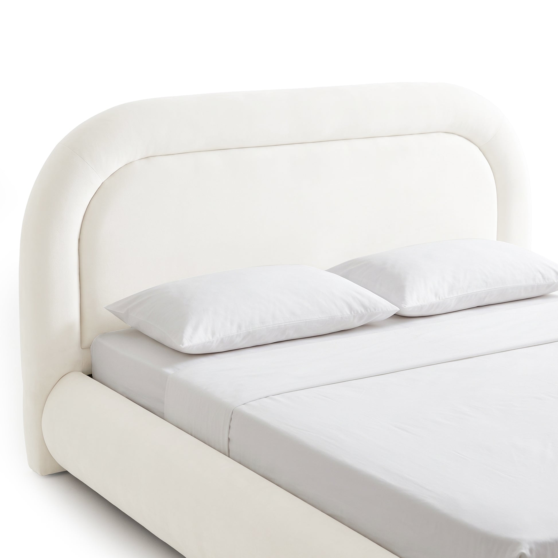 Cream white upholstered bed frame with curved headboard and gas lift storage base, shown with mattress and pillows