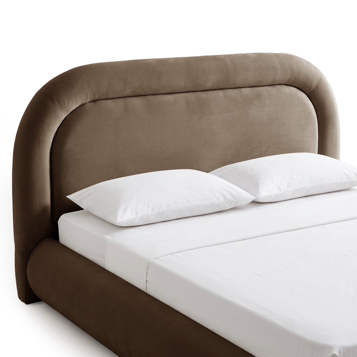 Close-up of taupe brown velvet upholstered headboard with curved edges and white bedding