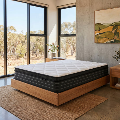 Iris Double Firm 25cm foam pillow top pocket spring mattress on wooden bed base in bedroom with large windows