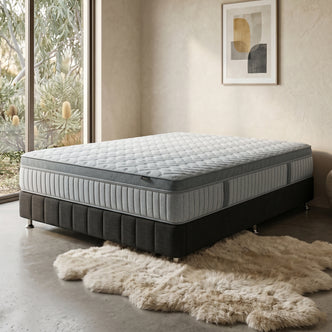 Layla pocket spring mattress styled on a black bed base with a fur rug.