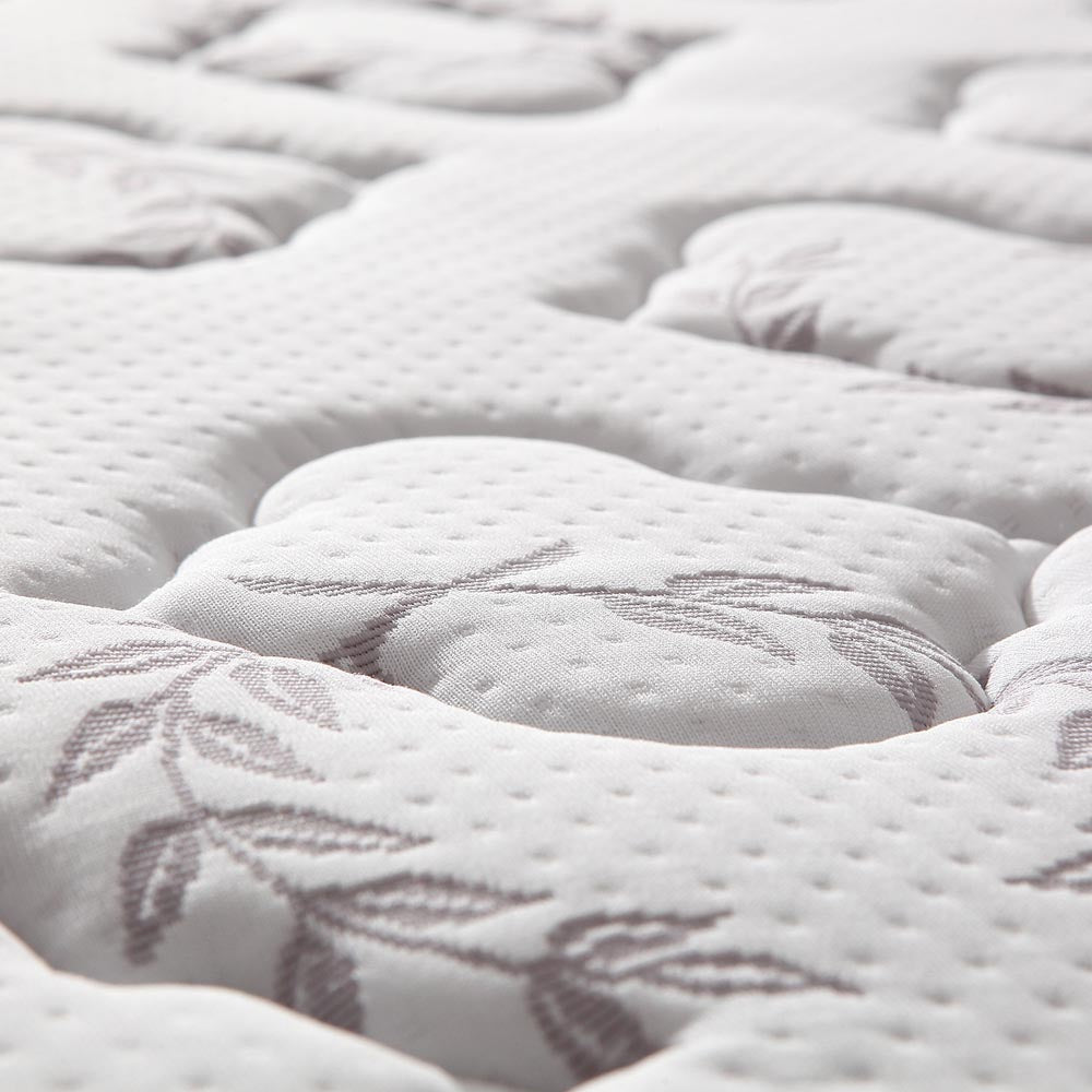 Close-up of quilted euro top mattress surface with leaf pattern embroidery and tufted cushioning