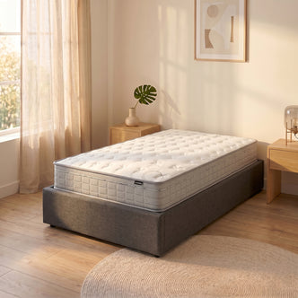 Thetis King Single 25cm Pocket Spring Latex Mattress with quilted white top and light grey sides on a grey upholstered bed