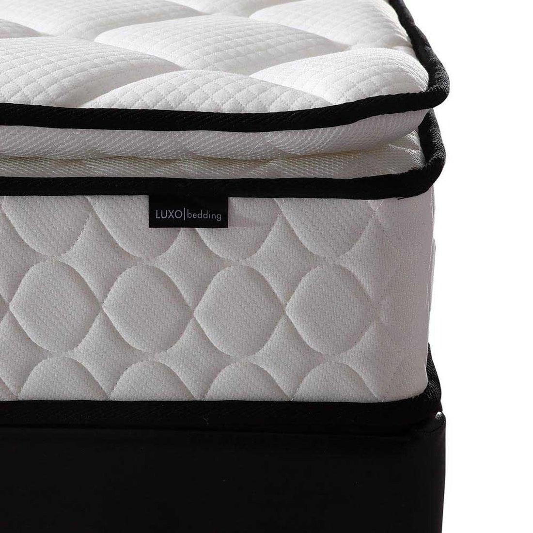 Close-up of the Luxo Venus mattress corner showing the pillow top layer, quilted side panel with circular pattern, and black