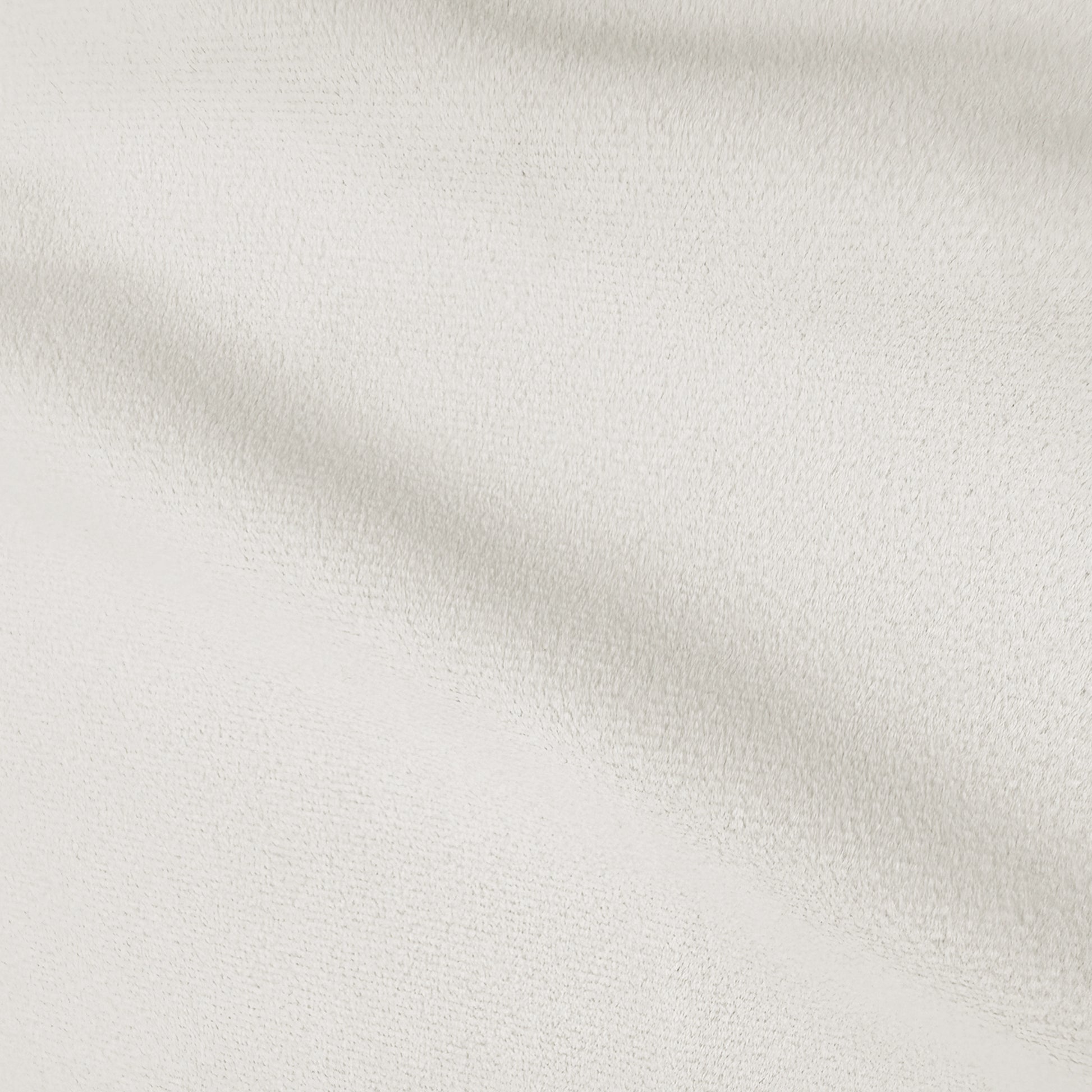 Close-up of cream white velvet upholstery texture showing soft plush pile and subtle shadowing
