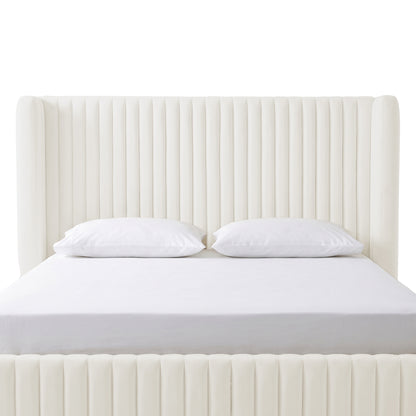 Cream white velvet upholstered bed with vertical channel tufting, white fitted sheet and two pillows