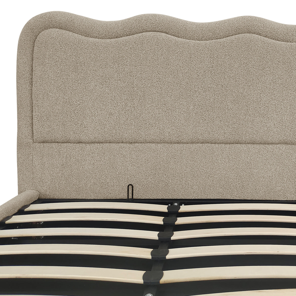 Close-up of beige boucle upholstered headboard and gas lift storage bed frame slats