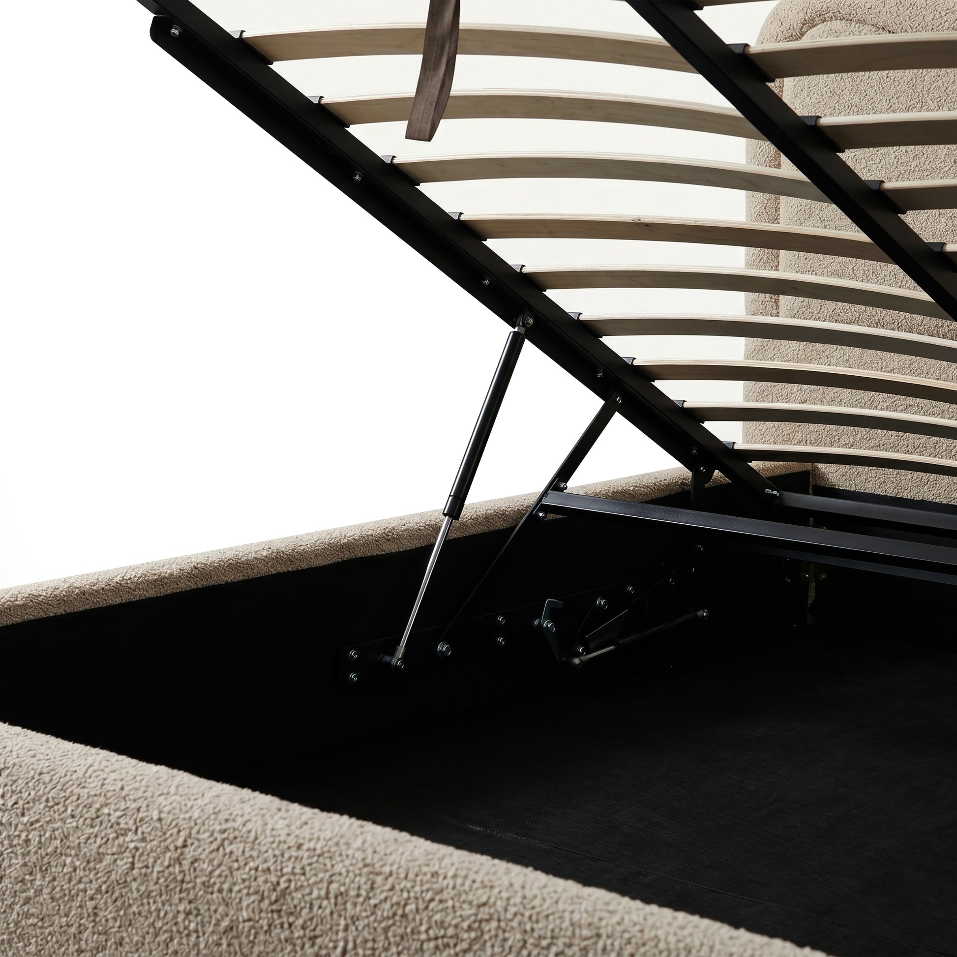 Beige boucle upholstered queen bed with gas lift storage mechanism, wooden slats and black metal frame visible