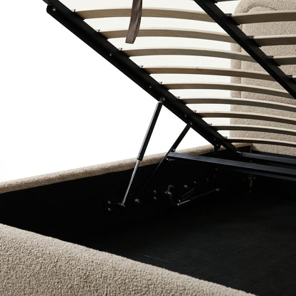 Beige boucle upholstered queen bed with gas lift storage mechanism, wooden slats and black metal frame visible