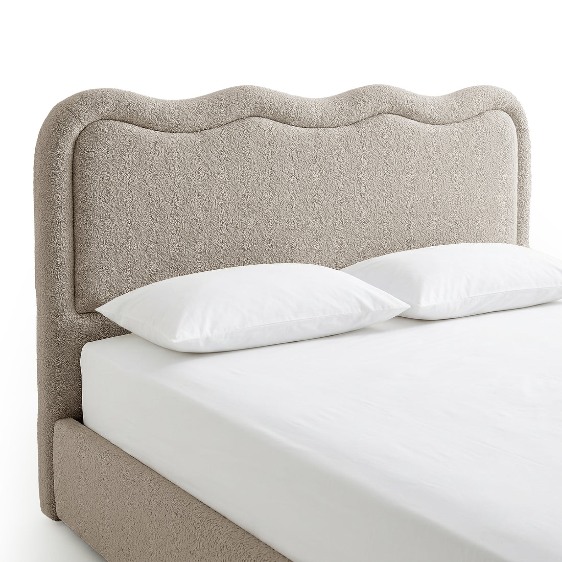 Beige boucle upholstered bed with curved scalloped headboard, white bedding and two pillows