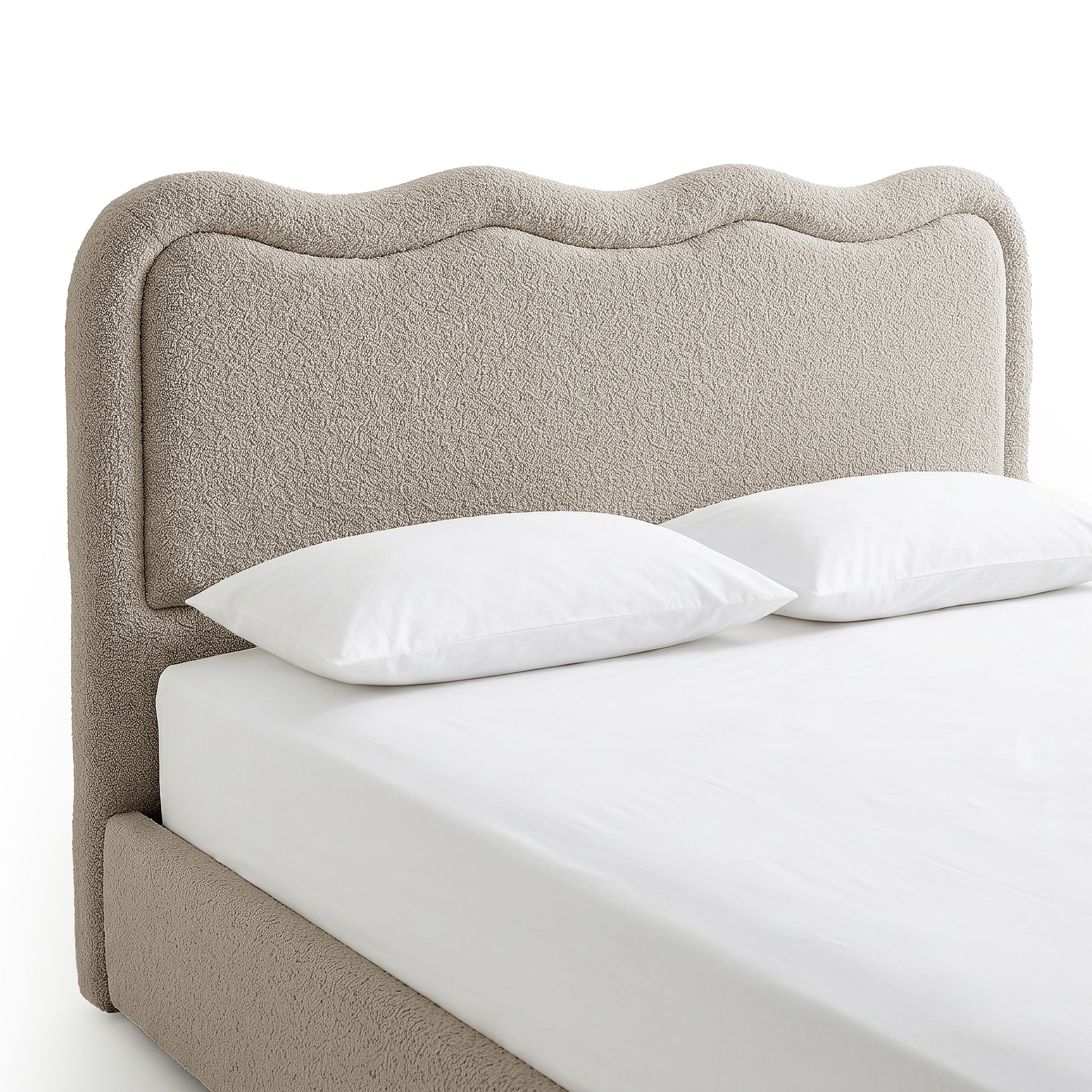 Beige boucle upholstered bed with curved scalloped headboard, white bedding and two pillows