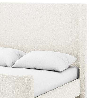 Close-up of cream white boucle upholstered headboard and footboard with light grey bedding on a sleigh bed frame