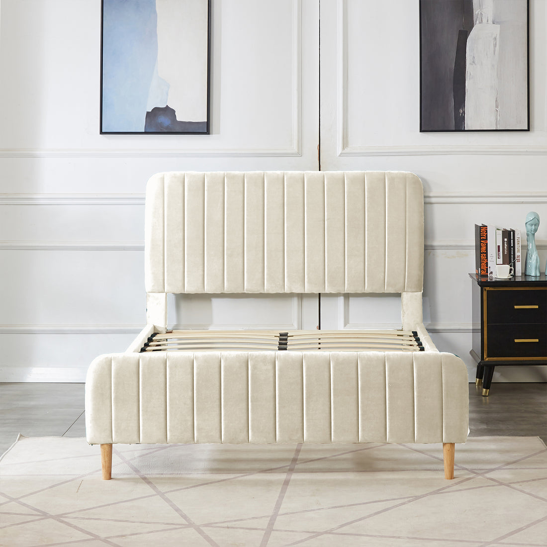 Seneca Double Upholstered Velvet Bed – Sandy White with vertical channel-tufted headboard, exposed wooden legs, and no mattress, set in a minimalist bedroom featuring abstract art and a black bedside table.
