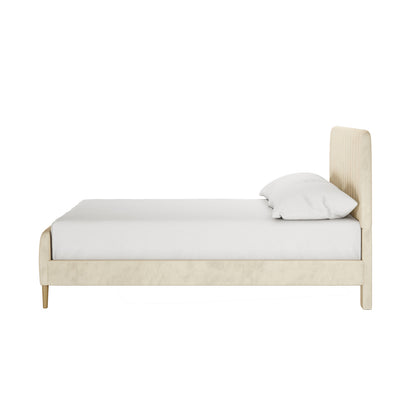 Seneca Double Upholstered Velvet Bed – Sandy White, side-view; light beige bed frame with a padded headboard, white mattress, and pillow, showcasing modern elegance and sturdy construction, against a plain background.