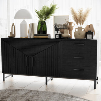 Black fluted sideboard buffet with geometric panel doors, three drawers and metal legs styled with vases, lamp and books